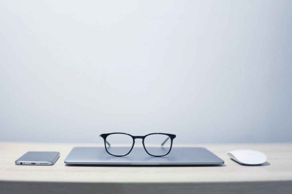 glasses on top of a laptop on a table
