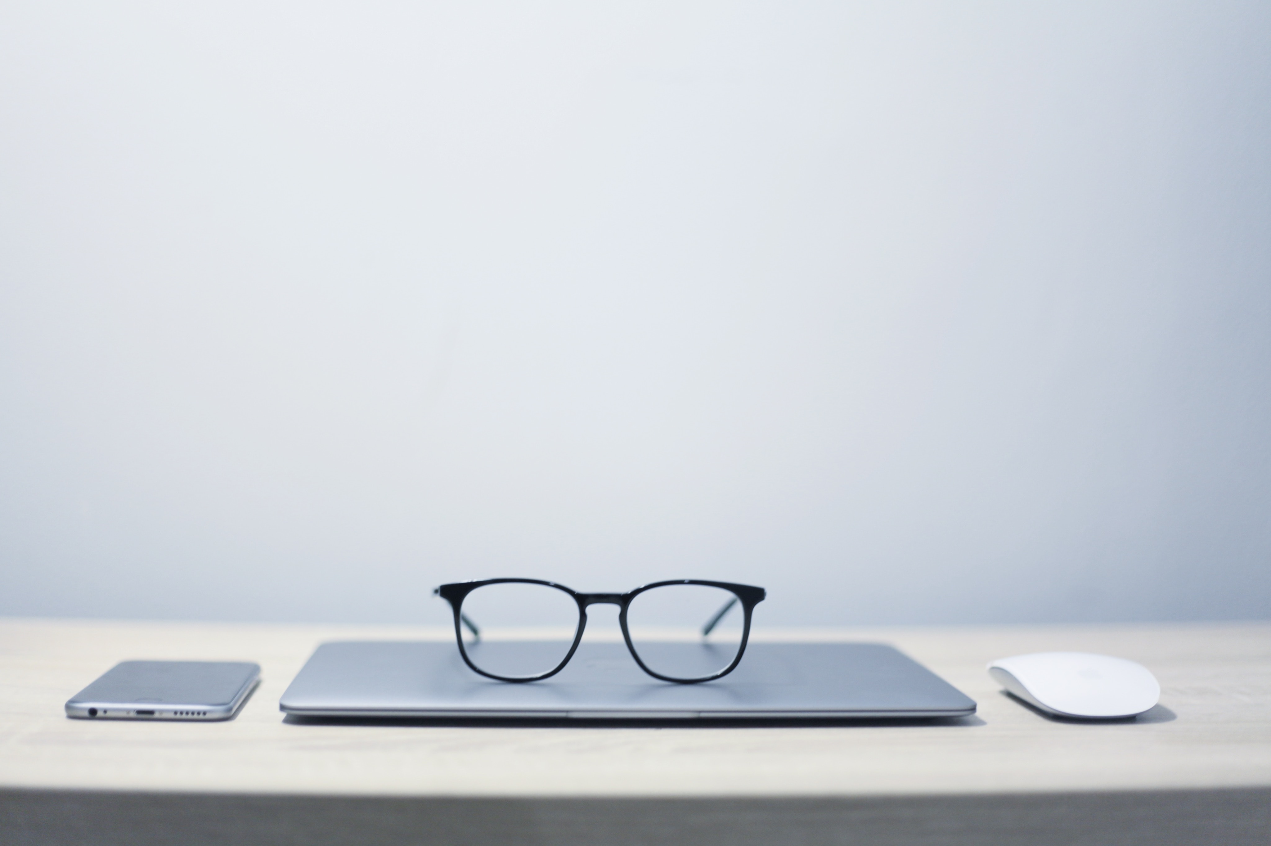 glasses on top of a laptop on a table